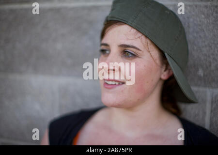 Frau steht neben Betonwand Stockfoto