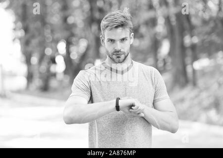 Sportler trainieren mit smart Watch. Einrichten fitness Tracker. Fitness Trainer. Nützliche Einstellungen. Armband Gadget. Athlet prüfen Fitness tracker Natur Hintergrund. Athleten aus schrittzähler Gadget. Stockfoto