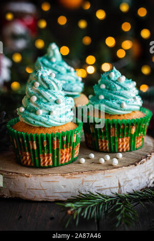 Mandarin Cupcakes mit festlich geschmückten Kappen von Butter Creme. Neues Jahr und Weihnachten Dessert. Stockfoto