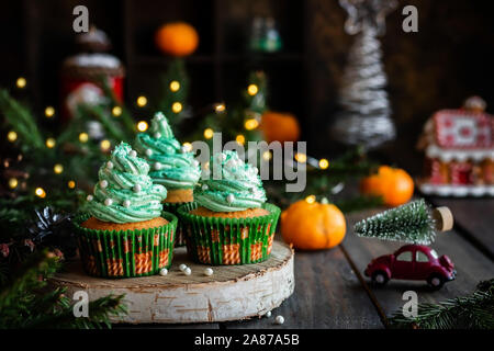 Mandarin Cupcakes mit festlich geschmückten Kappen von Butter Creme. Neues Jahr und Weihnachten Dessert. Stockfoto