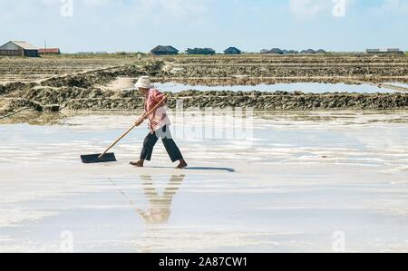 Die Provinz Kampot, Kambodscha - März 6, 2012. Eine weibliche Kambodschanische Arbeiter ernten Meersalz aus einer von mehreren Feldern auf einem Bauernhof, Salz produziert aus e Stockfoto