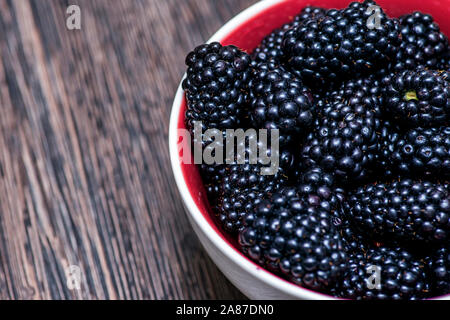 Mit Brombeeren Platte. Brombeeren auf Holz- Hintergrund. Süße, reife Brombeeren in der Schüssel. Stockfoto