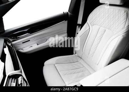Moderner Luxus Auto weiss Leder Interieur mit natürlichem Holz. Teil aus Leder Autositz details mit Ziernähten. Interieur mit Dashboard. White perf Stockfoto