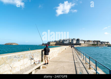 Dinard, Ille-et-Vilaine / Frankreich - 19. August 2019: Fischer auf der Hafenmauer Mole im historischen Französischen Stadt Saint-Malo Stockfoto