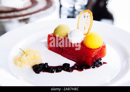 Kalte frische Wassermelone und gemischtes Obst Eis Sorbet auf der Oberseite mit süß-saurer Sauce Beeren in weißer Teller - Sommer gesund Dessert Stockfoto
