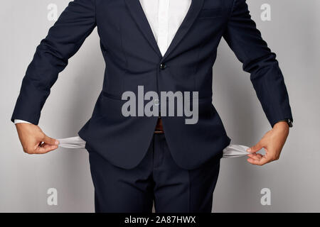 Junge Unternehmer mit leeren Taschen, studio Shot, auf weißem Hintergrund Stockfoto