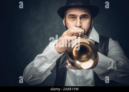 Jazz Trompeter auf einem dunklen Hintergrund. Portrait im Studio Stockfoto