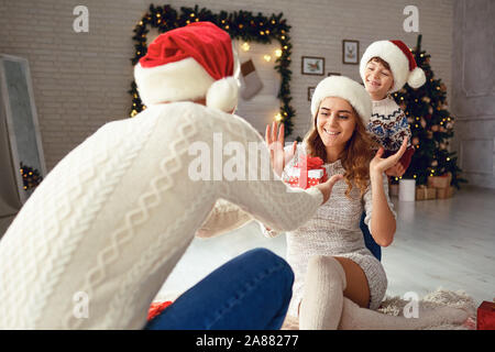 Die Familie bietet Kartons mit Geschenken für Weihnachten zu Hause. Stockfoto