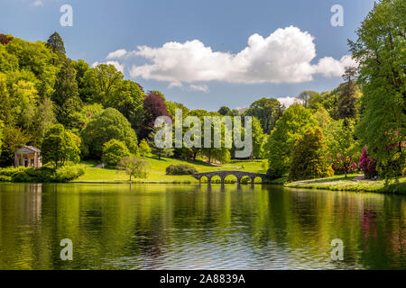 Die Palladianische Brücke und farbenfrohe Rhododendron blüht im Frühjahr an Stourhead Gardens, Wiltshire, England, Großbritannien Stockfoto