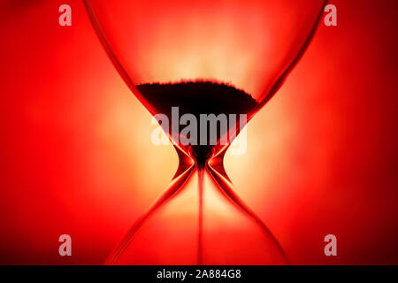 Crystal Sanduhr auf rotem Hintergrund, inspirierende Zeit Konzept Stockfoto