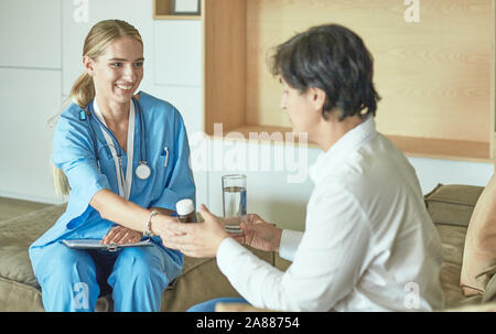 Schöne lächelnde Frau der Arzt in einer Flasche Pille bietet den Patienten. Stockfoto