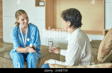 Schöne lächelnde Frau der Arzt in einer Flasche Pille bietet den Patienten. Stockfoto