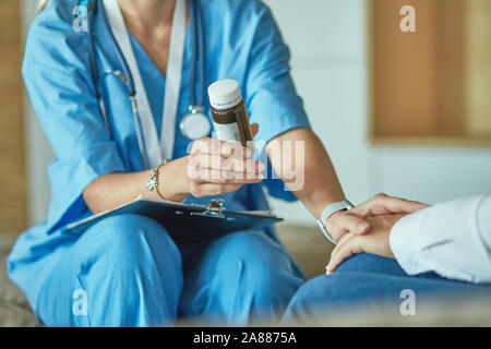 Schöne lächelnde Frau der Arzt in einer Flasche Pille bietet den Patienten. Stockfoto