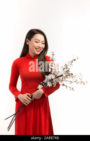 Frauen tragen traditionelle Vietnam Ao Dai holding Pfirsich Blüte in Tet Urlaub Stockfoto