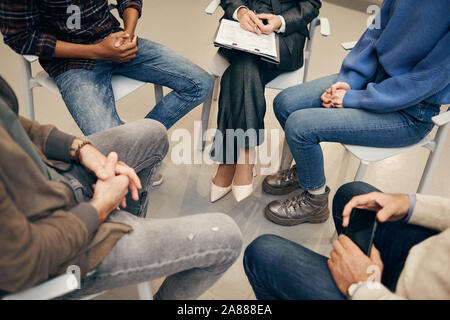 Nahaufnahme der Leute sitzen auf Stuhl im Kreis während der Therapie in der Klasse Stockfoto