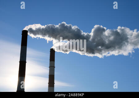 Stadtbild mit Rohren von thermischen Anlagen vor blauem Himmel Hintergrund. Ökologie Probleme. Umweltverschmutzung. Stockfoto