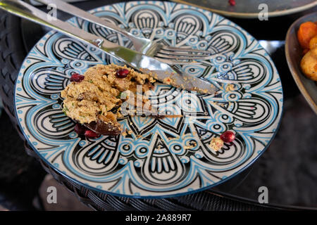 Essensreste auf einem Teller. Messer und Gabel auf einem Teller nach dem Essen. Abendessen in einem Café. Traditionelle georgische Essen. Stockfoto