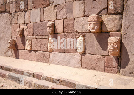 Stein zapfen Köpfe auf den Wänden der halb-unterirdischen Tempel in Tiwanaku archäologischen Komplex, Bolivien Stockfoto