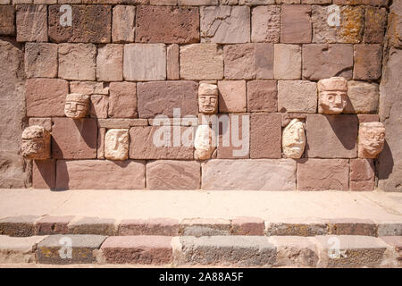 Stein zapfen Köpfe auf den Wänden der halb-unterirdischen Tempel in Tiwanaku archäologischen Komplex, Bolivien Stockfoto