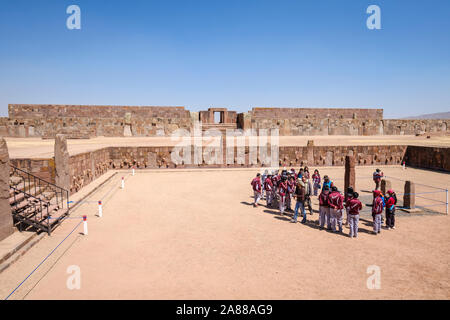 Bolivianischen Studierenden in Schuluniform auf halb-unterirdischen Tempel Eingang in Tiwanaku archäologischen Komplex, Bolivien Stockfoto