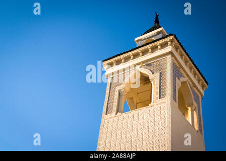 Tunesische Minarett. Low Angle View eines traditionellen Minarett Tower, ein unverwechselbares architektonisches Merkmal von Moscheen. Medina, Tunesien und Nordafrika. Stockfoto