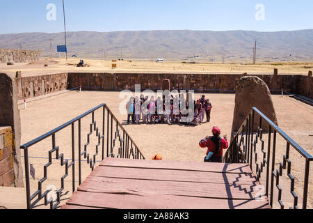 Bolivianischen Studierenden in Schuluniform auf halb-unterirdischen Tempel Eingang in Tiwanaku archäologischen Komplex, Bolivien Stockfoto