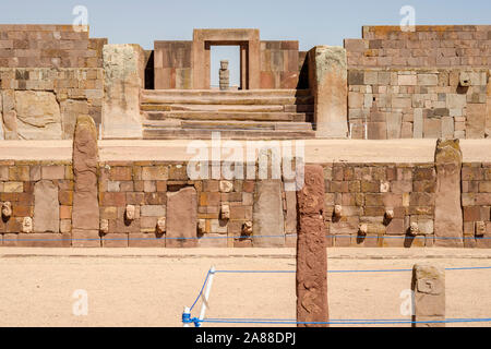 Zapfen, Köpfe auf der halb-unterirdischen Tempel mit der Kalasasaya Tempel und Ponce monolith im Hintergrund Tiwanaku archäologischen Komplex, Bolivien Stockfoto