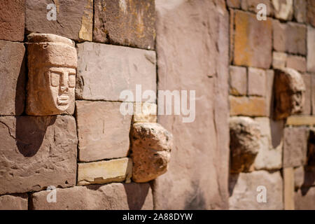 Stein zapfen Köpfe auf den Wänden der halb-unterirdischen Tempel in Tiwanaku archäologischen Komplex, Bolivien Stockfoto