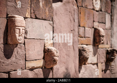 Stein zapfen Köpfe auf den Wänden der halb-unterirdischen Tempel in Tiwanaku archäologischen Komplex, Bolivien Stockfoto