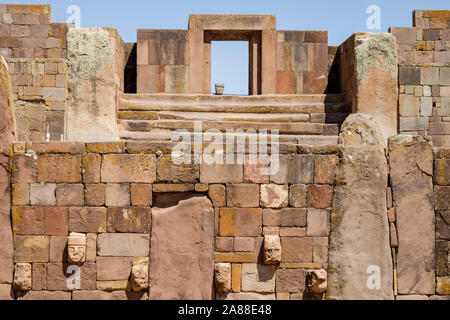 Zapfen, Köpfe auf der halb-unterirdischen Tempel mit der Kalasasaya Tempel und Ponce monolith im Hintergrund Tiwanaku archäologischen Komplex, Bolivien Stockfoto