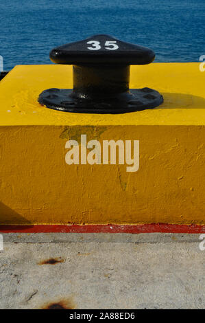 Schwarze festmacher Post mit der Nummer 35 steht auf gelb Beton im Hafen Stockfoto