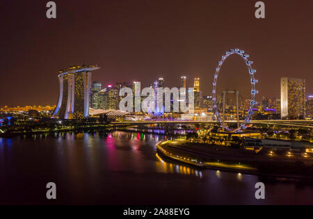 Singapore Flyer Riesenrad und Marina Bay Sands mit Sicht auf die City Skyline bei Nacht beleuchtet Stockfoto