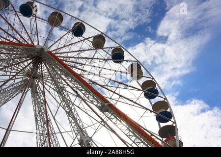 Riesenrad messe Attraktion Gegenlicht der Sonne vor einem blauen Himmel und weißen Wolken Stockfoto