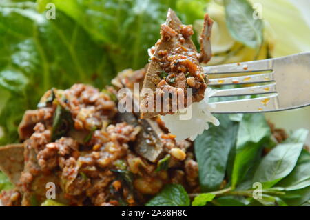 Würziges gehacktes Schweinefleisch und Leber Salat mit klebrigem Reis Stab in der Gabel Stockfoto