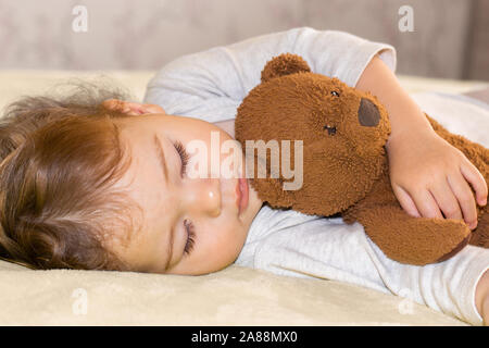 Little Baby schlafen umarmen ein Teddybär, Nahaufnahme portrait. Kind Mädchen Kaukasischen jungen Schlaf süß im Schlafzimmer Stockfoto