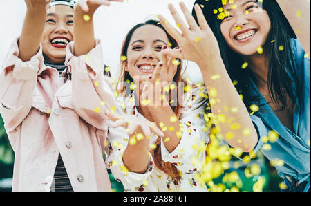 Happy asiatischen Freunden Spaß werfen Konfetti Outdoor - junge trendige Leute an Festival Veranstaltung außerhalb Feiern Stockfoto