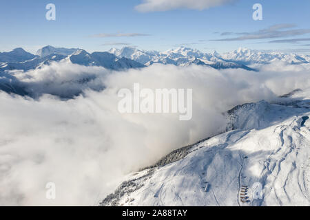 Luftaufnahme von einem Wald mit frischem Schnee und Wolken in der Aletsch Arena. Die Schweiz im Herbst Stockfoto