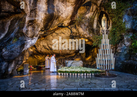 Lourdes (Frankreich). Pilger an der Grotte von Massabielle, am Ufer der Gave de Pau Fluss Stockfoto