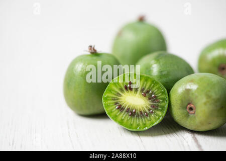 Nahaufnahme der einige Reife kiwi Beeren auf einem weißen rustikalen Tisch Stockfoto