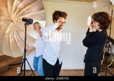 Modell und Foto Assistent an Beleuchtung für Fotoshooting im Fotostudio Stockfoto