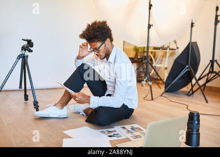 Nachdenklich Fotograf bei der Auswahl der Fotos nach dem Fotoshooting Stockfoto