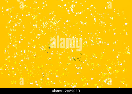 Festliche Hintergrund mit kleinen goldenen Sternen auf gelben Hintergrund. Flach. Stockfoto