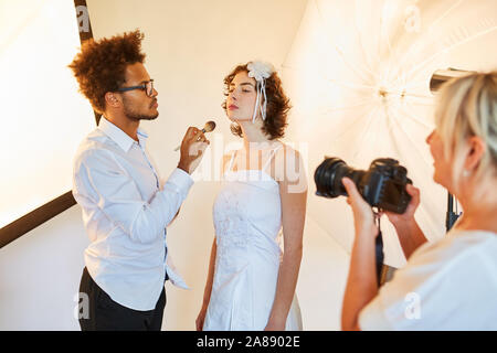 Make-up Artist mit Braut am Hochzeitstag Anwendung Make-up für das Fotoshooting Stockfoto