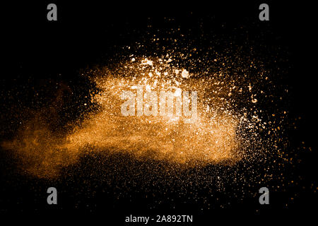 Abstrakte orange Pulver Explosion auf schwarzen Hintergrund. Freeze Motion von orange Staub Splash. Malte Holi Pulver. Stockfoto