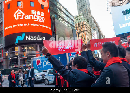 Mitarbeiter mit ihren Familien und Freunden sammeln an der riesigen Bildschirm an der Nasdaq Börse in Times Square in New York für das Debüt des FangDD Network Group (DUO) Börsengang am Freitag, den 1. November 2019 eingerichtet. FangDD Network Group ist ein on-line-Immobilien Markt in China bietet Werkzeuge auf eine mobile Plattform für Immobilienmakler. (© Richard B. Levine) Stockfoto