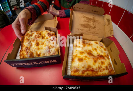 Ein hungriger Kunde greift sich eine Scheibe bei einer Franchise von Jet Pizza im New Yorker Stadtteil Chelsea am Freitag, 1. November 2019. Jet Pizza verkauft Detroit Stil Pizza. (© Richard B. Levine) Stockfoto