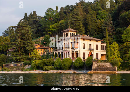 Villa am Meer in der Nähe von Bellagio, während am späten Nachmittag Bootsfahrt am Comer See, Lombardei Italien Europa EU Stockfoto