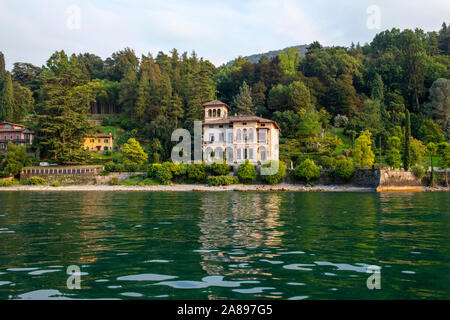 Villa am Meer in der Nähe von Bellagio, während am späten Nachmittag Bootsfahrt am Comer See, Lombardei Italien Europa EU Stockfoto