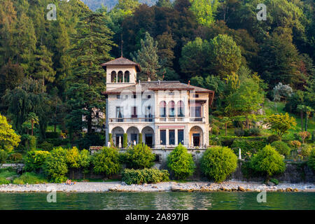 Villa am Meer in der Nähe von Bellagio, während am späten Nachmittag Bootsfahrt am Comer See, Lombardei Italien Europa EU Stockfoto