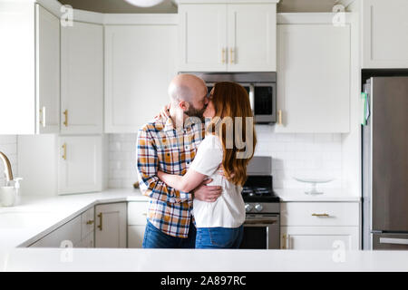 Paar küssen in Küche Stockfoto